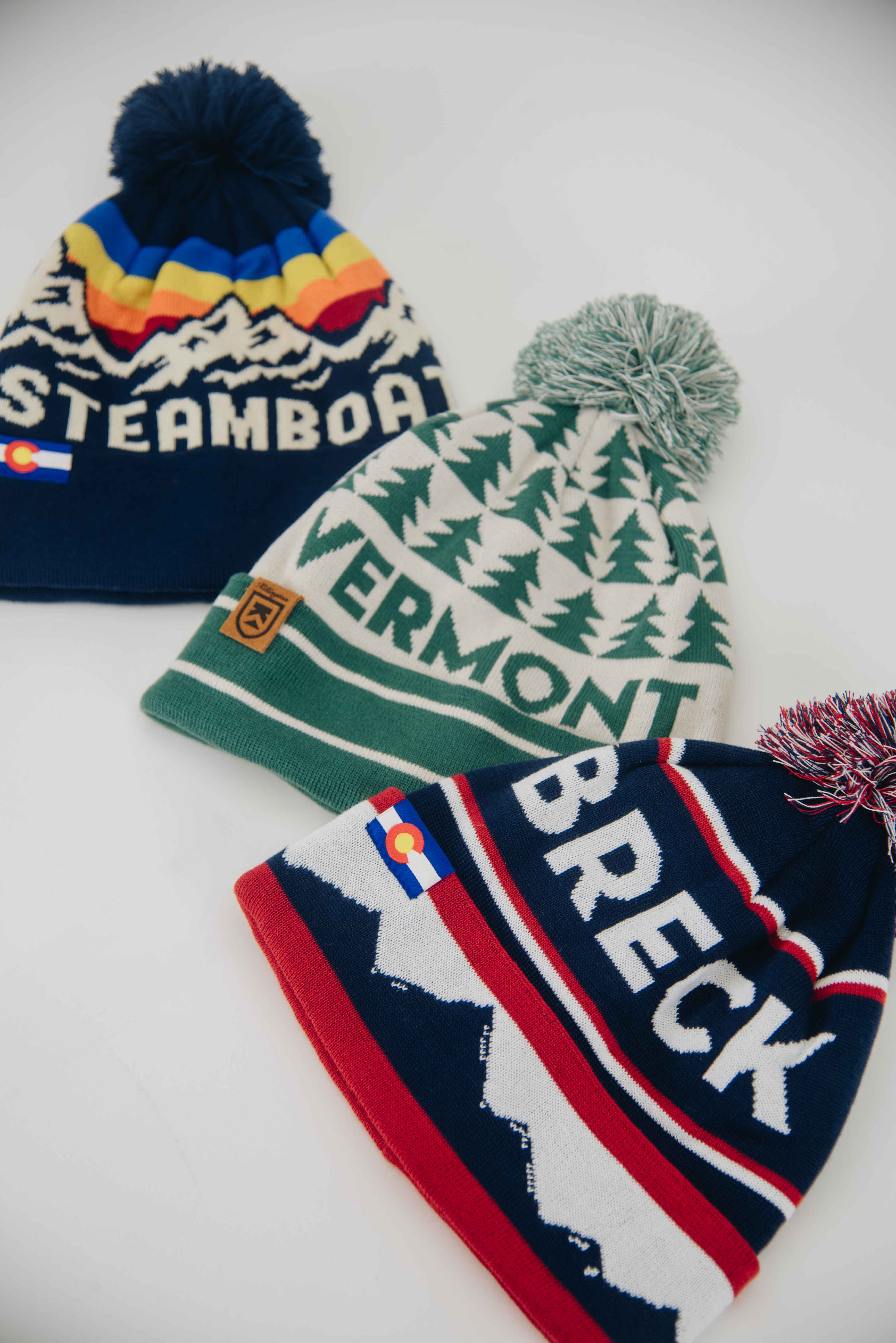 three beanies laying on a white studio floor
