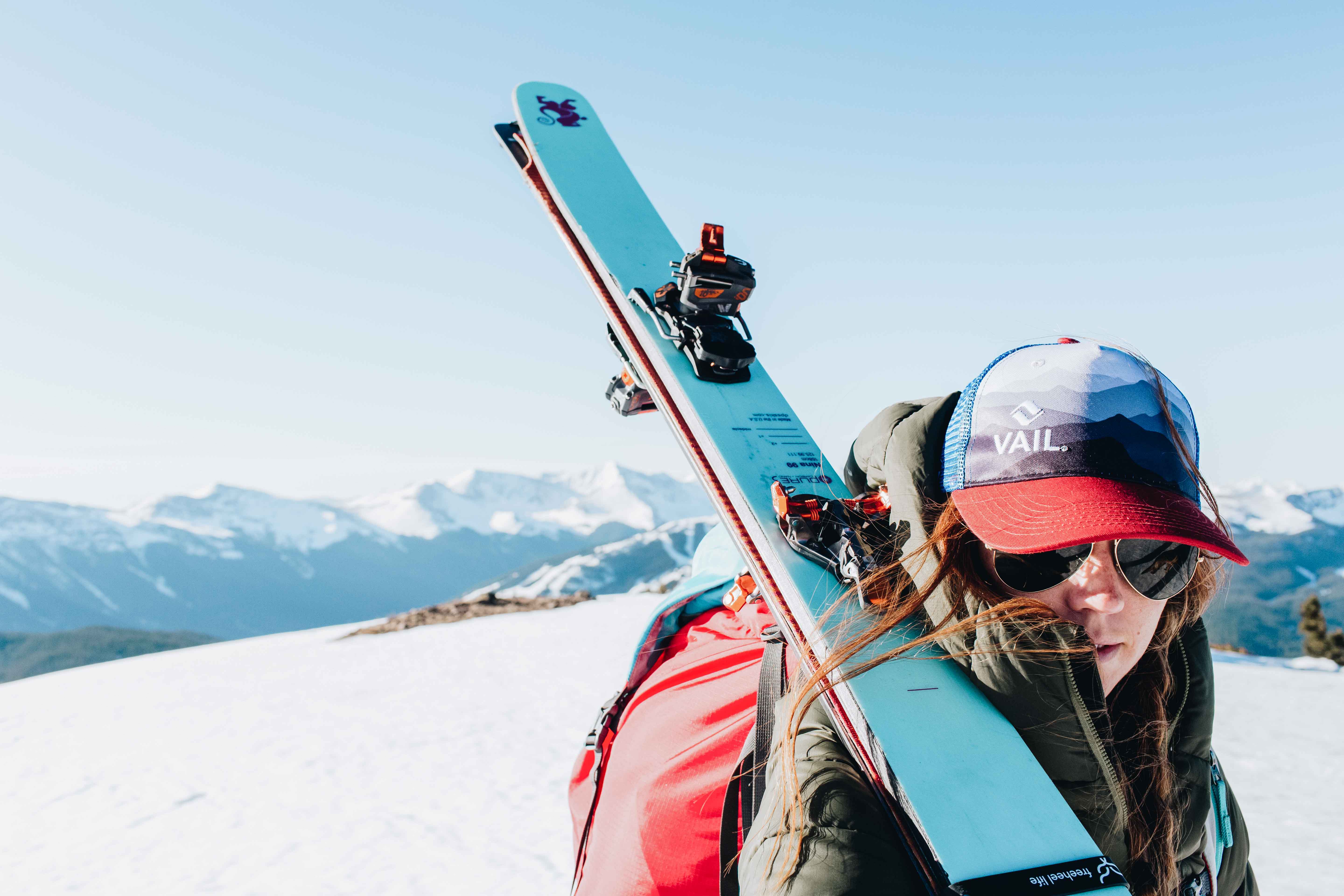 Person holding a ski with a mountainous landscape in the background